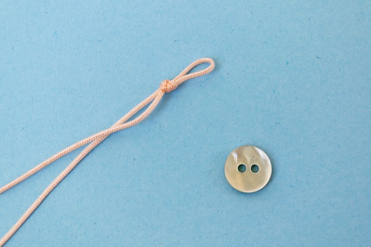 Make a loop in the cord that just fits your button